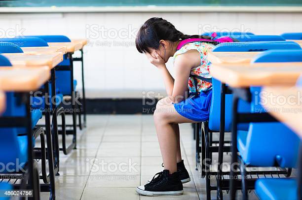 sad girl sitting and  thinking in the classroom