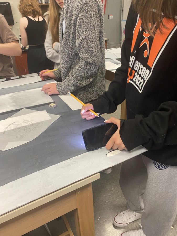 Once the background is finalized, students start sketching their characters onto the mural. They first start by using pencil to make sure everything fits and looks correctly before going in with acrylic paint. 
