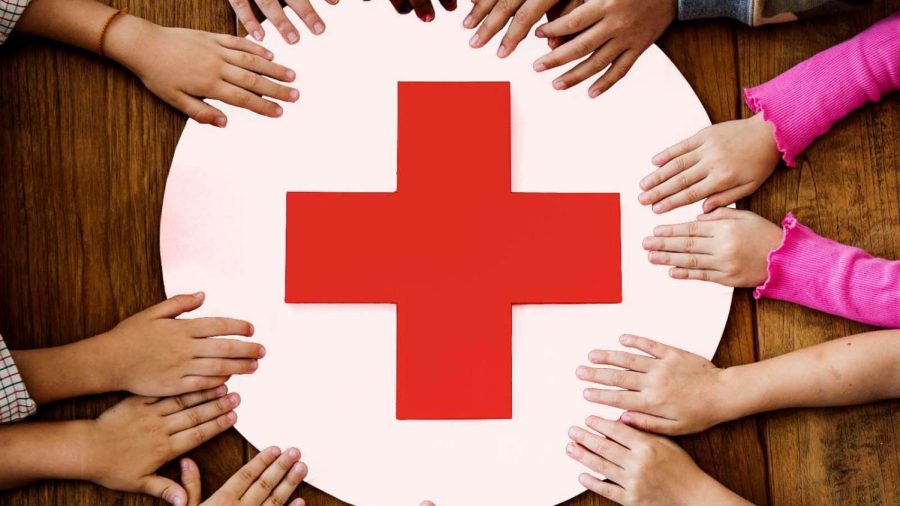 The Red Cross logo with hands surrounding it, representing the organization’s purpose of coming together for a good cause.